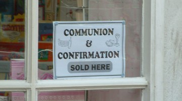 A sign offering communion and confirmation for sale