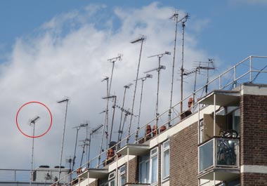 A roof image with all antenna's except one facing in the same direction