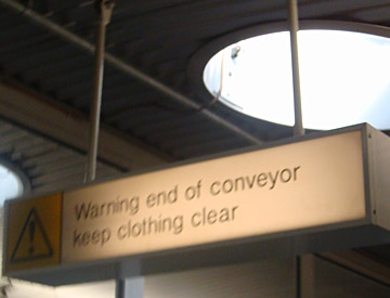 Warning end of conveyor keep clothing clear