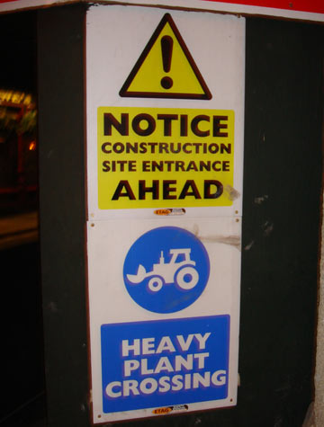 Construction site entrance sign advising heavy plant crossing