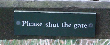 Sign on the gate reading 'Please shut the gate'