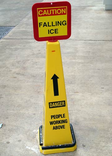 Sign warning of falling ice and people working overhead