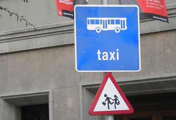 Street sign with with the word taxi under a bus icon