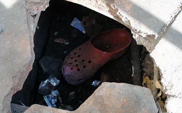 Croc dropped in sidewalk hole