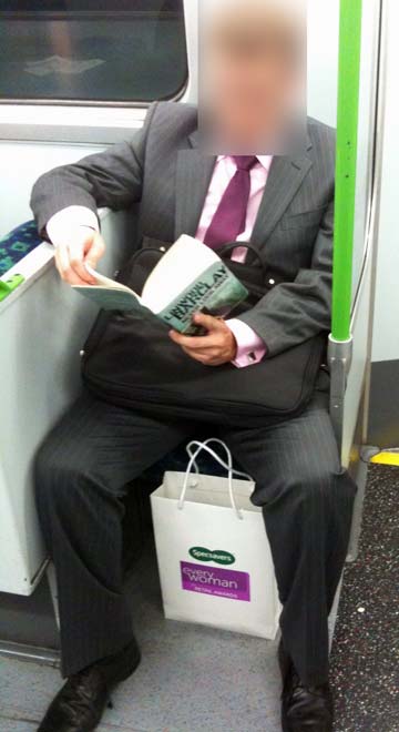 Man on a Tube train with a bag at his feet