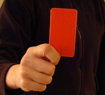 A hand holding a red card