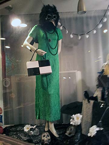 A female mannequin in a green dress, with a crow's head