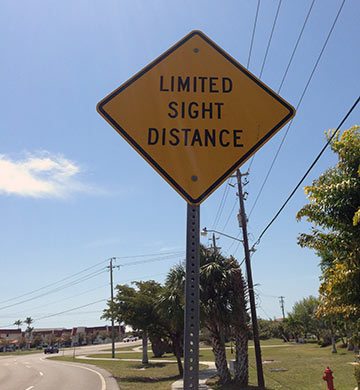 A sign reading "limited sight distance"