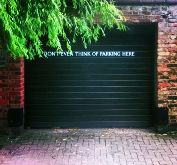 Garage door with sign reading Don't even think of parking here