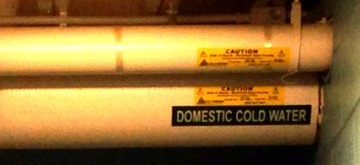 Pipe with sticker reading "Domestic cold water"