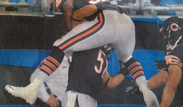 A football player jumping into the face of another player