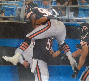 A football player jumping into the face of another player