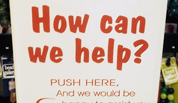 A "How can we help?" sign