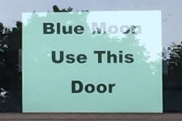 A sign reading "Blue Moon Use This Door"