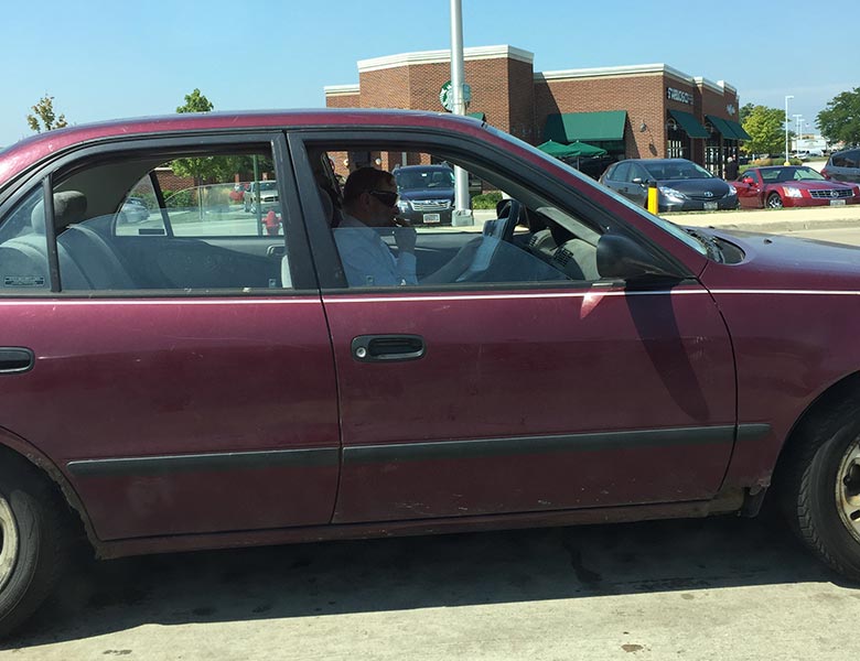 A driver reading a newspaper at the red light